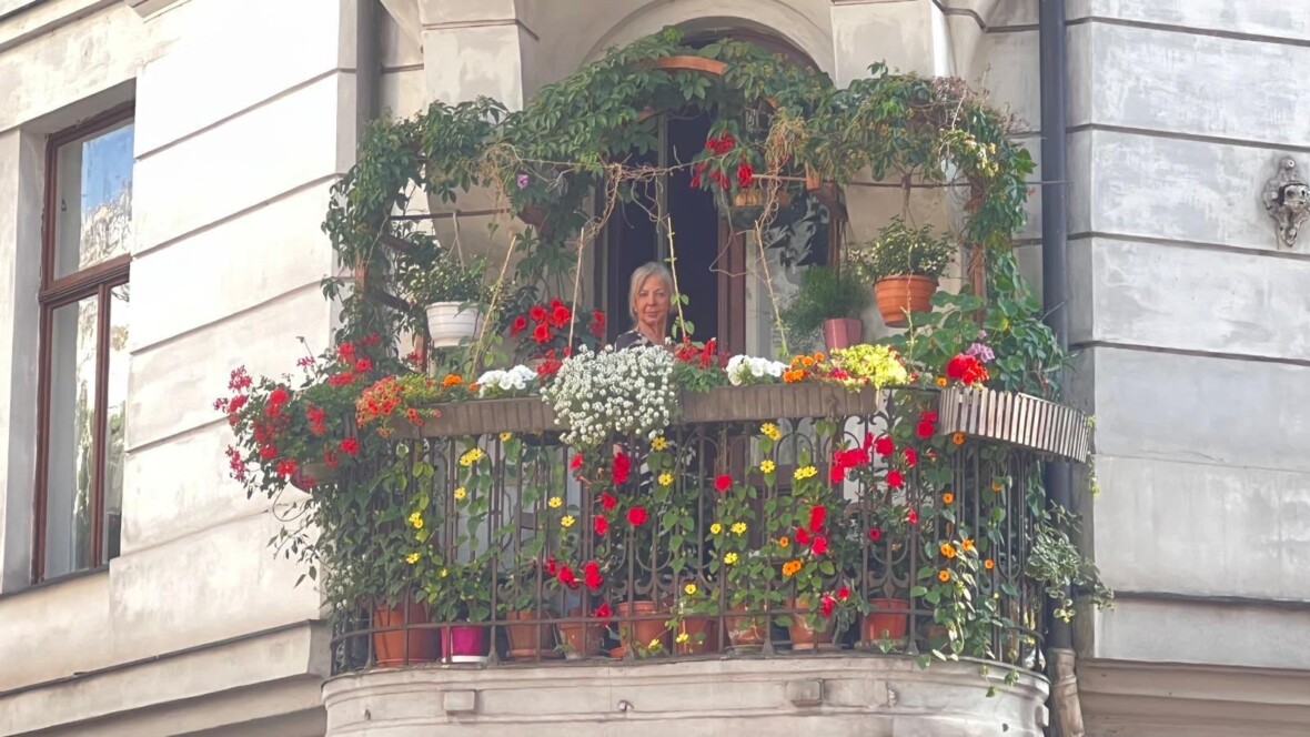 Renate Bachmayer auf einem begrüntem Balkon